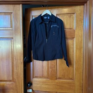 Black shirt with sleeve cuffs able to be tightened for riding. A zipper front